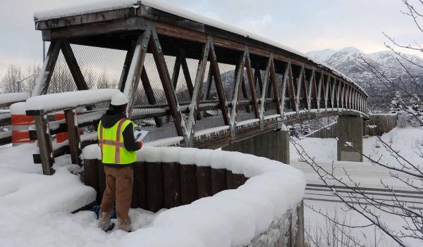 A worker standing at one end of a bridge