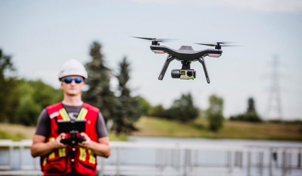 A field worker operates a drone