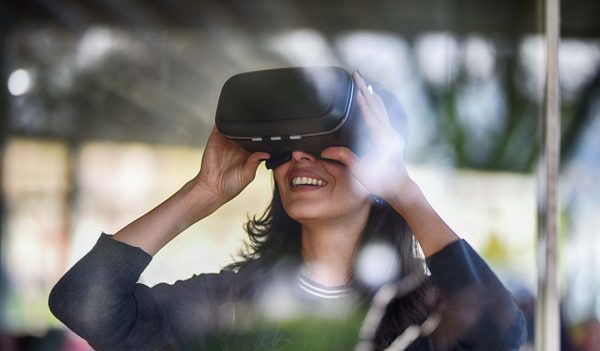 Young woman looking with VR behind the glass