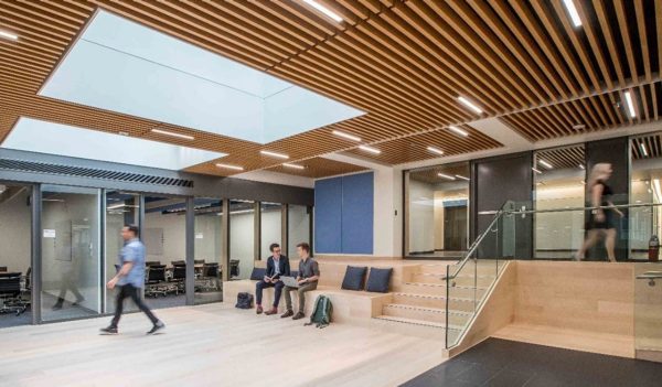 People moving through and working in fourth floor collaboration space with large skylights.