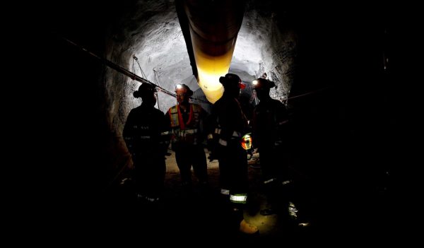 Mine designers in shadowy mine tunnel