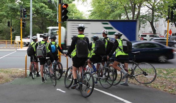 biker riders at bike path/street intersection