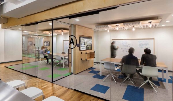 Interior of a coworking space picturing collaboration in a meeting room.