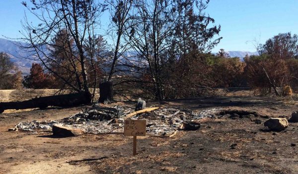 Ash remains of a cabin lost to a wildfire.