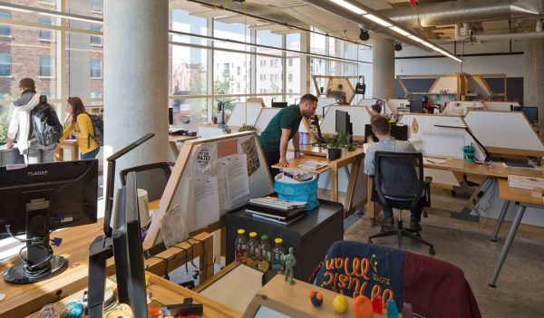 Colleagues collaborating inside an office within the renovated McCullough Building and new George Gund Building.