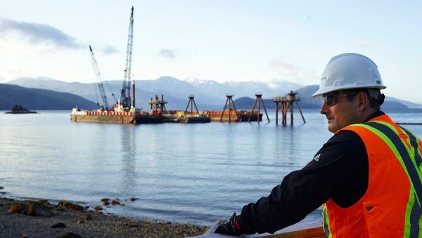 Worker with mining crane at lake