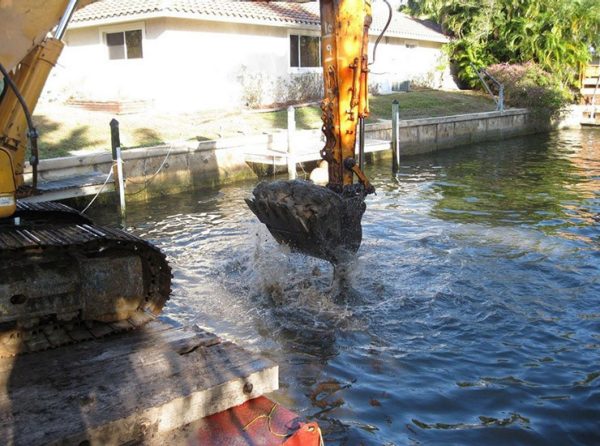 barge-mounted excavator mechanically dredges a canal