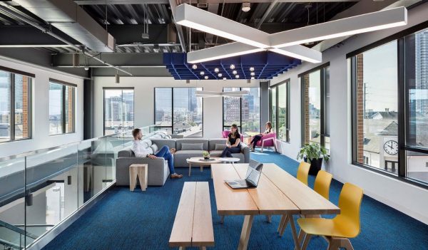 Employee lounge with family style table and chairs, and soft seating area