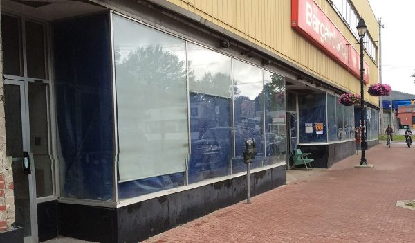 Exterior of an old store front on an urban street.