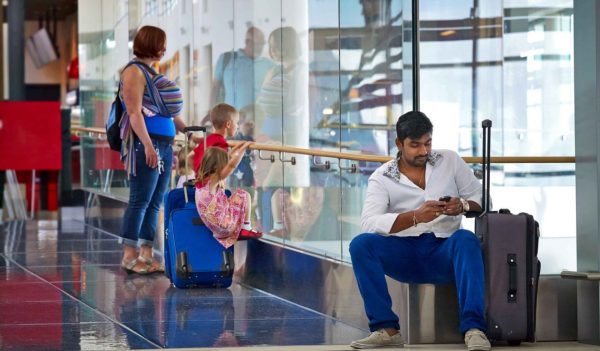 People waiting in airport terminal with luggage