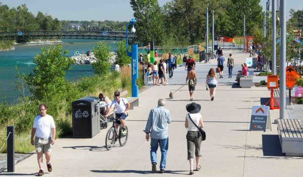 People walking on landscaped path along river front