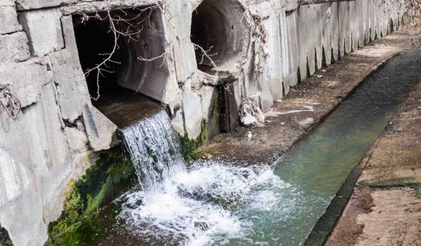 Two large concrete run-off pipes discharging water