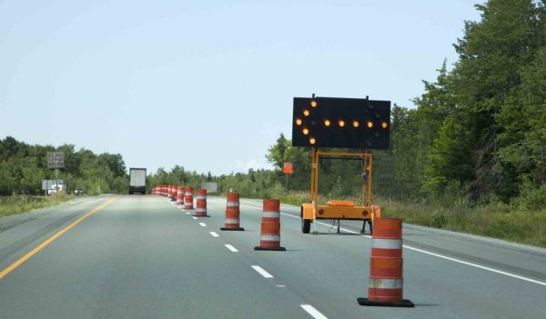 Sign on highway indicating to keep left due to construction