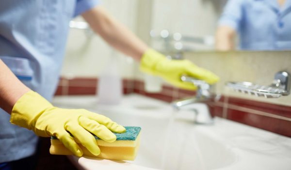 Janitor cleaning sink in hotel room