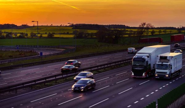 Colourful sunset at M1 motorway near Flitwick junction with blurry cars in United Kingdom.