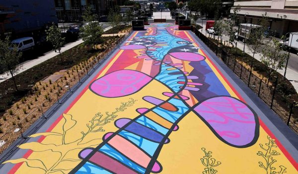 Locomotion plaza after renovations. Brightly painted plaza with landscaping on each side.