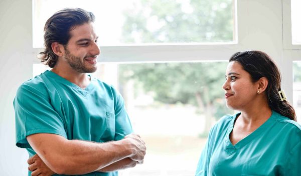 Two medical professionals talking near a window.