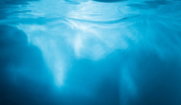 Abstract blue background. Water with sunbeams