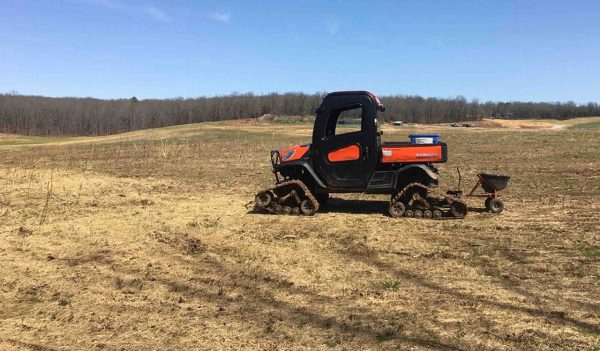 All terrain vehicle in a field used for seeding.