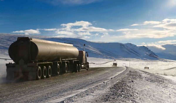 Tankers and trucks driving the Dalton Highway through the Brooks Range mountains Alaska