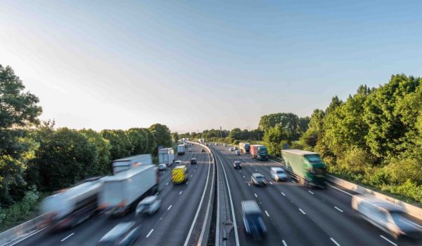 Sunset view heavy traffic moving at speed on UK motorway in England.