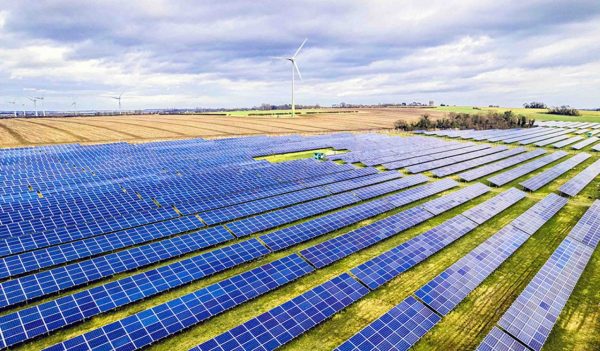 Aerial shot of Large solar farm and wind turbine, UK