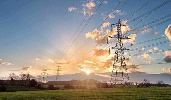 Electricity Pylon - UK standard overhead power line transmission tower at sunset.