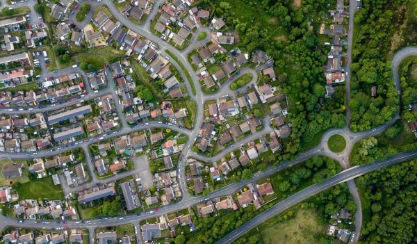 Top down aerial view of an urban area in a small town surrounded by trees and greenery