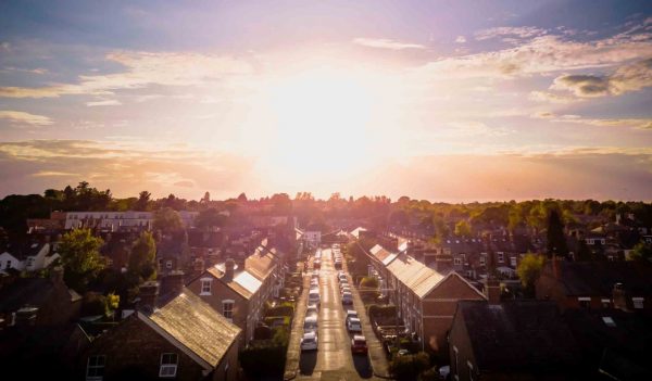 Sunset over traditional British houses with countryside in the background.  A picturesque scene, created by the long shadows and warm glow