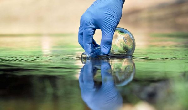 Hand in glove collects water for testing. 