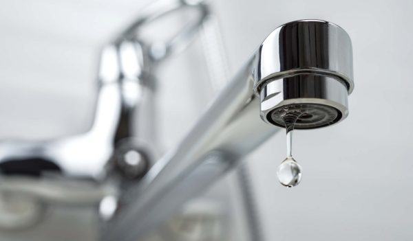 A drop of water dripping from the tap. 