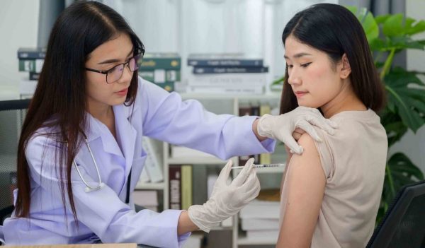 Asian female doctor hand wearing medical gloves vaccinations or injections in the arm to protect against viruses and influenza