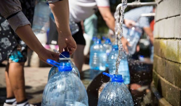 People filling water bottles at a filling station. 