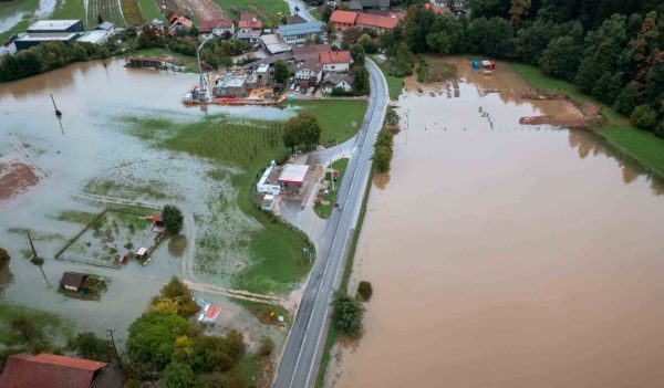 Flash flood caused by heavy rainfall, a torrent from mountain stream ripping through the forest into the valley, aerial view.