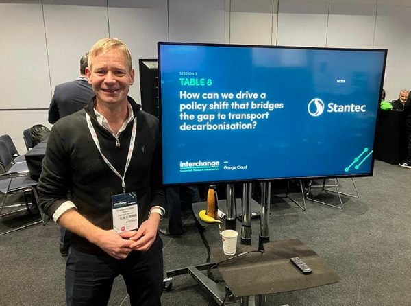 Graham Hughes standing in front of a digital display.