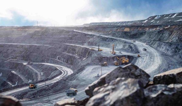 Work of heavy equipment in an open pit for gold ore mining, soft focus