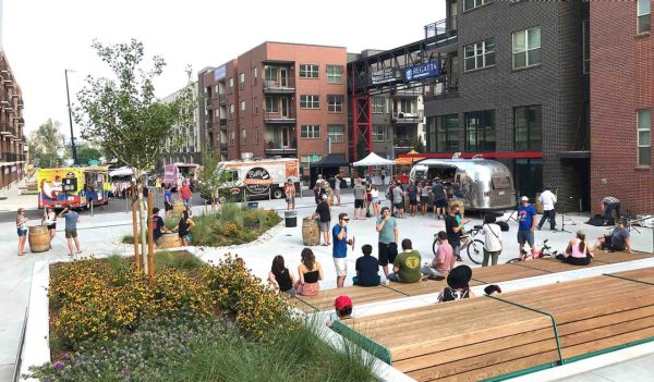 Rendering of an outdoor event in the square with people and food trucks.