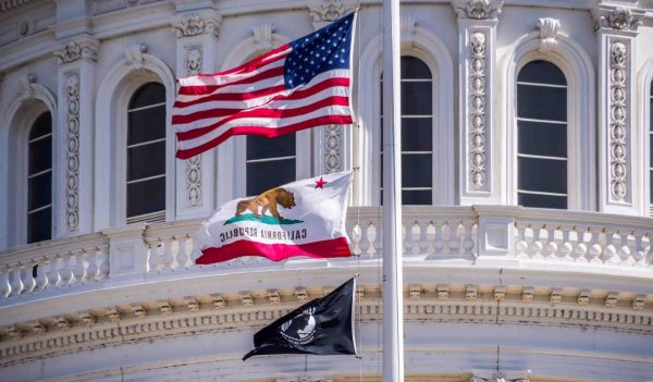 The US flag, the California flag and the POW-MIA flag waving in the wind in front of the Capitol State Building in downtown Sacramento