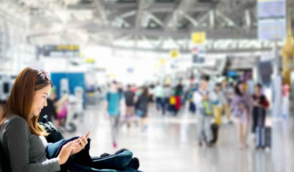 Closeup of a woman sitting in an airport terminal with the background blurred.