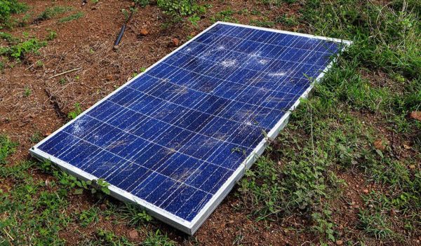 Broken solar panel lying on the ground.