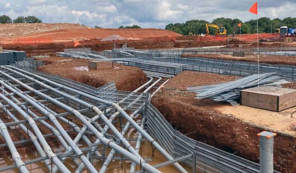 Construction site of underground utilities being installed under a building.