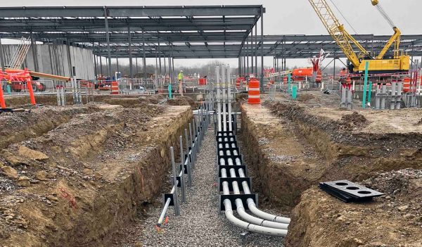 Construction site of underground utilities being installed under a building.