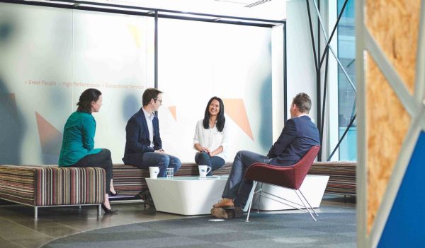 Elliot Alfirevich, Nikki Solana, Sally Batho, Darren Pesich sitting on benches having a meeting.