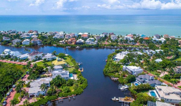 Aerial view of Bonita Springs showign houses along the canal and the ocean.