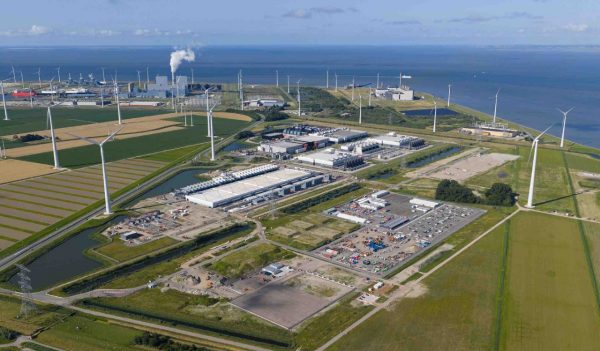 Aerial view of a data center, surrounded by wind turbines in Eemshaven, Groningen, The Netherlands. hyperscaler. Aerial video