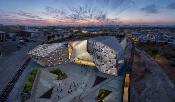 AI rendering of the exterior building campus of a fictional aerospace company at dusk.