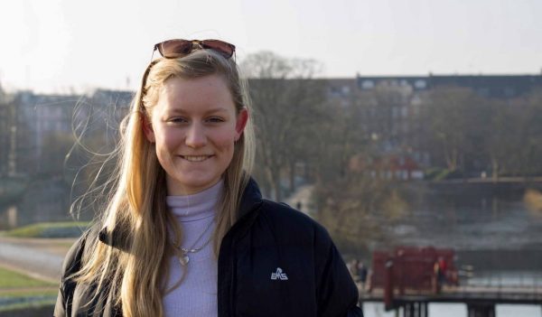 Close-up of Emily Downs outside with a walking path and water in the background.