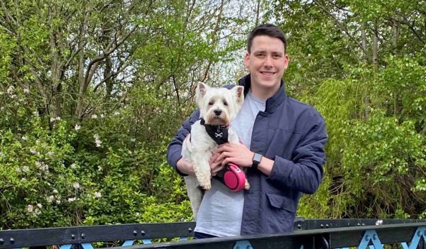 Henry standing on a bridge with his dog.