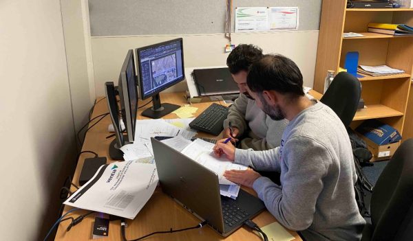 Maninder working with a colleague at a desk.