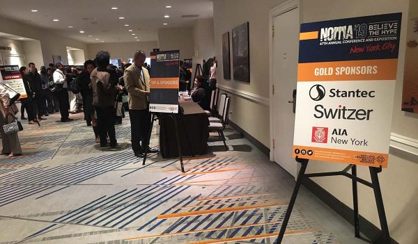 People in the hallway of the conference with information tables